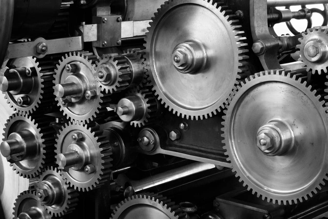 why-choose-us Close-up view of a complex industrial gear mechanism in black and white.